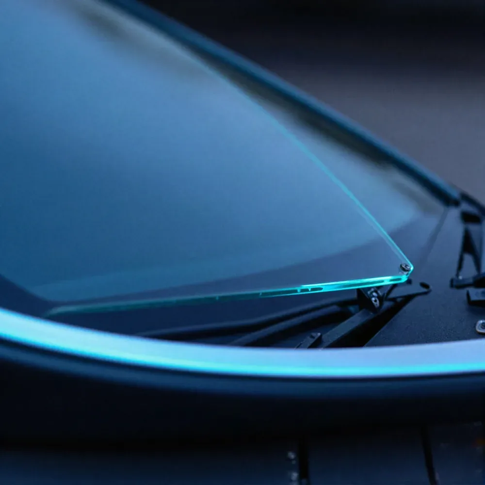 Close-up of the edge of a newly fitted windshield seated against a car's cowl